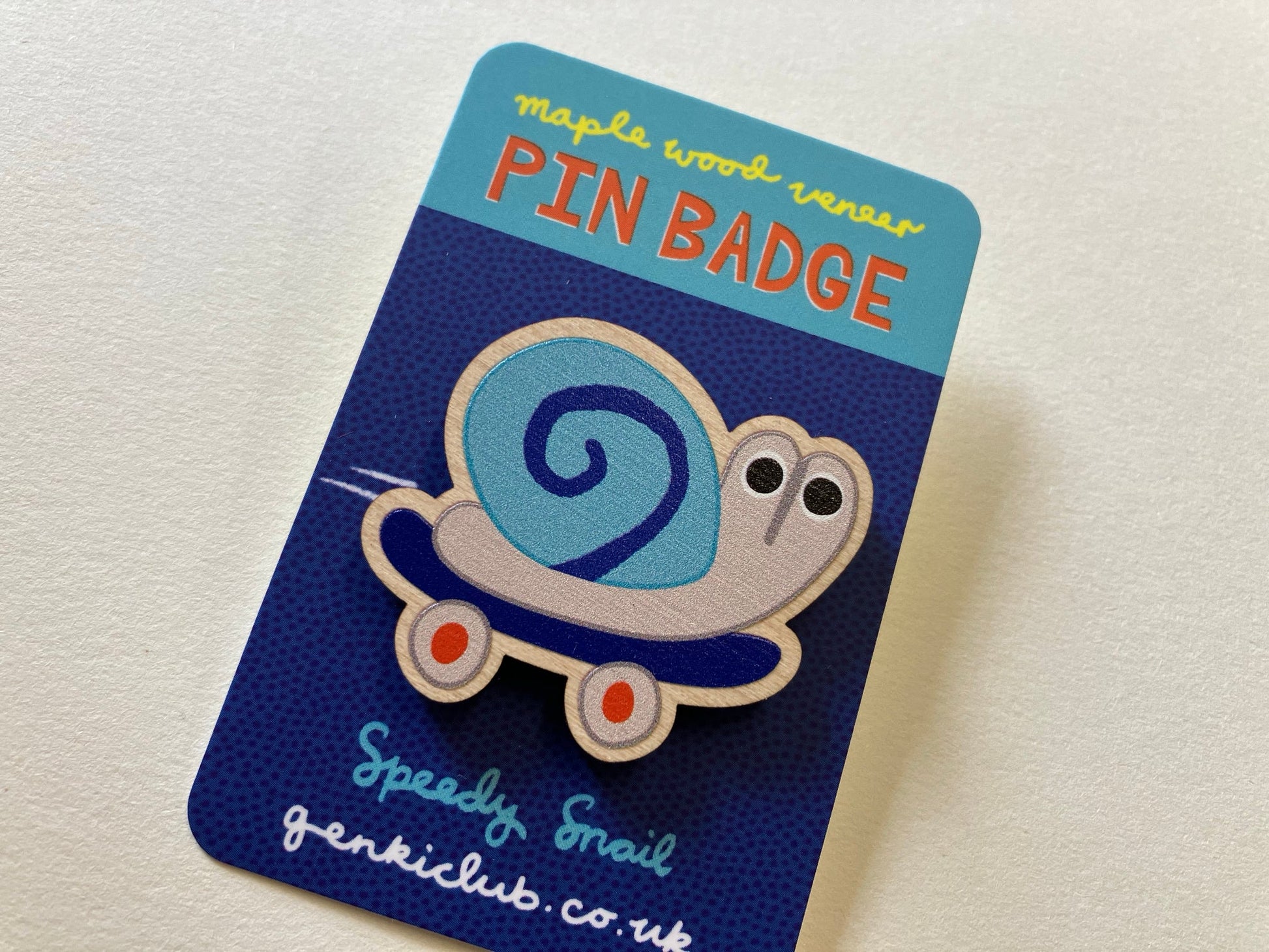 Pin badge on a blue card with 'Speedy Snail' branding